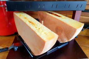 A wheel of melting Raclette ready to pour over Nacho s or roasties