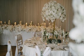 White rose and orchid wedding table centre pieces with top table floral styling