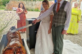 Bride and groom cutting hog roast