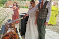 Bride and groom cutting hog roast