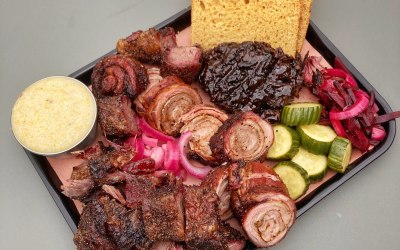 A tray of rolled lamb breast, beef short ribs, bbq glazed hen of the woods mushroom, cheese grits, pickles, and beef tallow brioche.