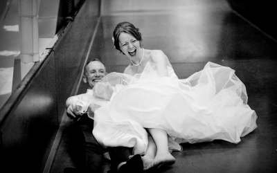 Bride and father enjoying big slide