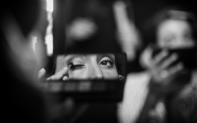 Bride putting on make up in mirror 