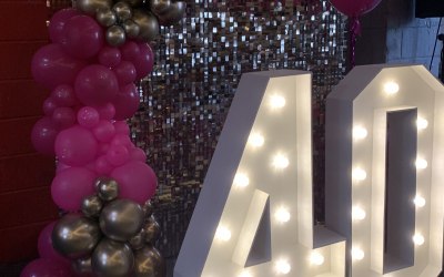 Gold shimmer backdrop, LED numbers and Balloon decor