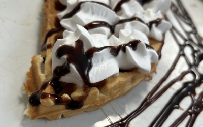 Belgian waffle drizzled with milk chocolate and edible dried rose petals